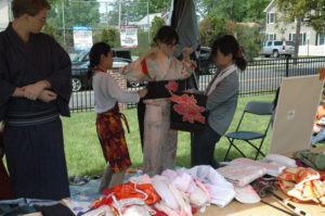 Two Harrison residents try on kimonos at a booth at the Harrison Matsuri held at Ma Riis Park. Photo/Sibylla Chipaziwa