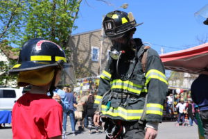 Benji Schenk, 5, speaks to a Harrison firefighter wearing full turnout gear. Photo/Andrew Dapolite
